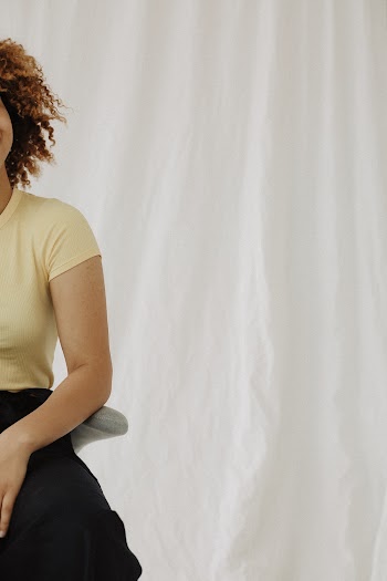 Woman in Beige T-shirt Beside Wall