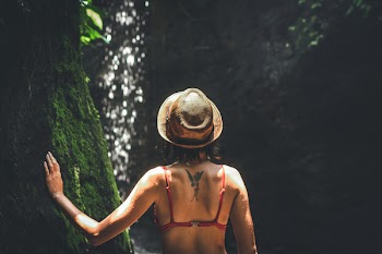 Woman in Bikini Top Wearing Hat Touching Tree