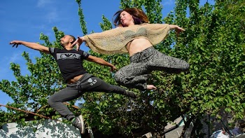 Woman in Black and Grey Pants Beside Man in Black Gap Pants Surrounded by Trees
