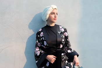 Woman in Black and Pink Floral Robe Leaning on Wall