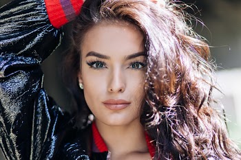 Woman in Black and Red Jacket Holding Her Head Photo