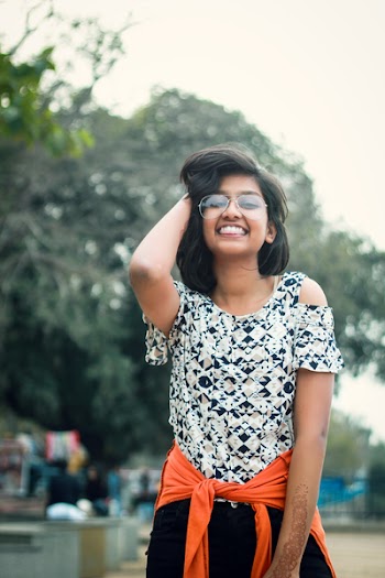 Woman in Black and White Floral Top Holding Her Hair