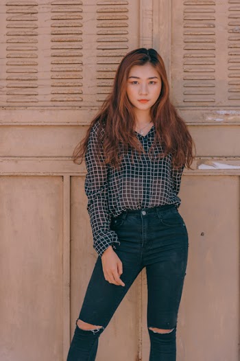 Woman in Black and White Grid Pattern Long-sleeved Shirt Against the Wall