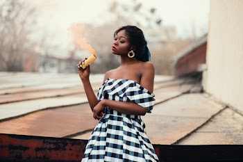 Woman in Black and White Off-shoulder Dress Standing Near on Brown Wood Panel