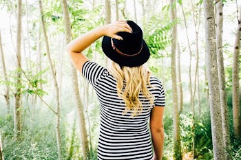 woman in black and white striped crew-neck shirt surrounded by trees during daytime