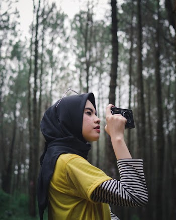 Woman in Black and White Striped Long Sleeve Shirt Holding Black Camera