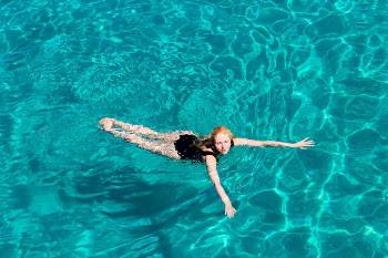 Woman in Black Bikini Swimming in Pool