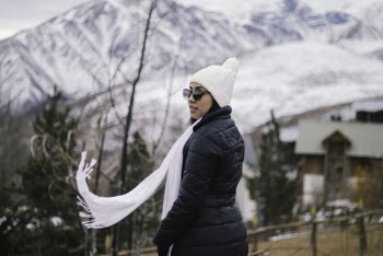 Woman In Black Bubble Jacket And White Scarf