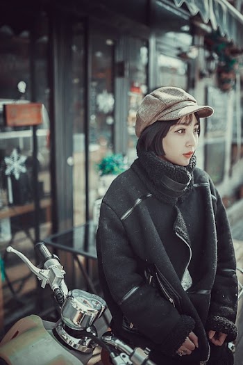 Woman in Black Coat Sitting on Motorcycle
