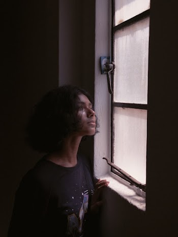 Woman in Black Crew-neck T-shirt Facing Closed Glass Window