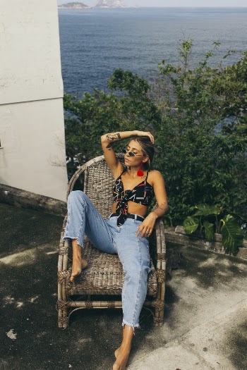 Woman in Black Crop Top Sitting on Brown Wooden Armchair