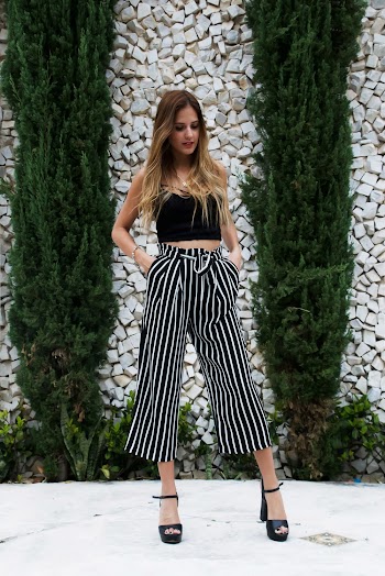 Woman in Black Crop Top Standing Near Arbor Vitae