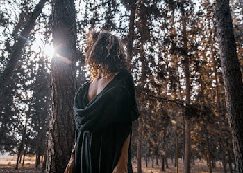 Woman in Black Dress beside a Tree