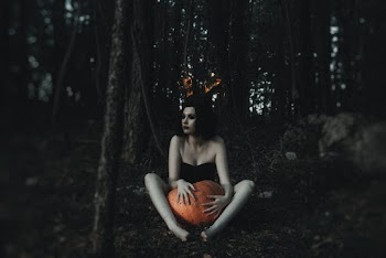 Woman In Black Dress Holding A Pumpkin