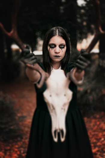 Woman in Black Dress Holding Animal Skull