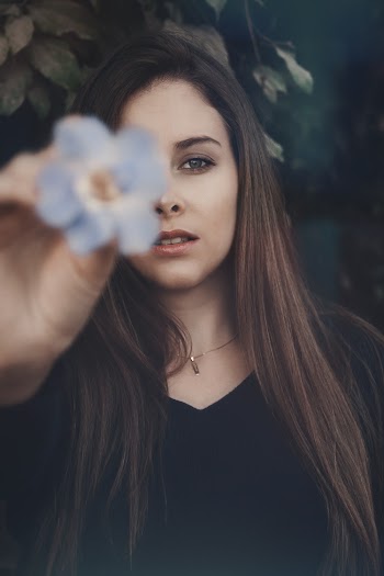 Woman in Black Dress Holds Purple Flower