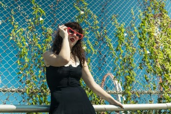 Woman in Black Dress Leaning On A Steel Railing