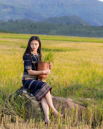 Woman in Black Dress Sitting on Rock