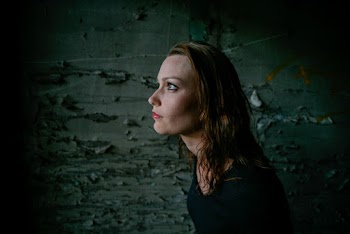 Woman In Black Dress Standing By The Wall With Peeling Paint