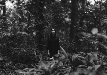 Woman in Black Dress Standing In The Woods