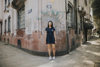 Woman in Black Dress Standing Infront of a Building