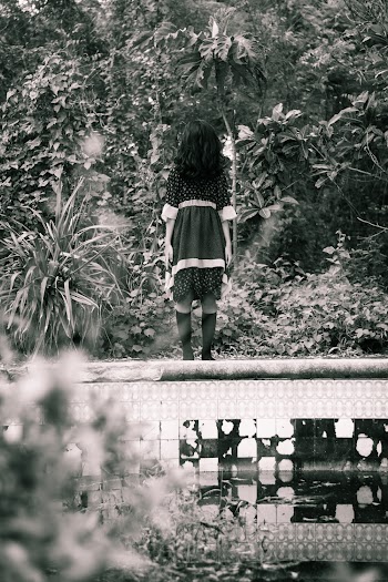 Woman in Black Dress Standing on Wall