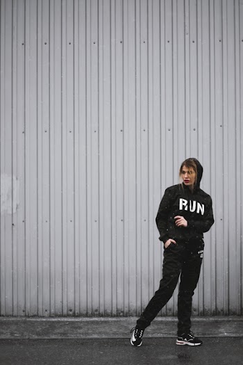 Woman in Black Hoodie, Pants, and Sneakers