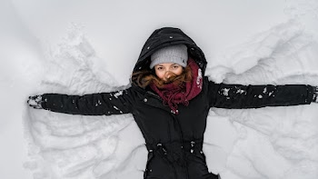 Woman in Black Jacket and Gray Knit Cap on Snow Covered Ground