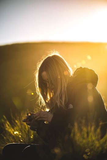 woman in black jacket holding black DSLR camera