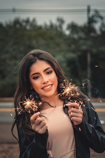 Woman in Black Jacket Holding Sparklers
