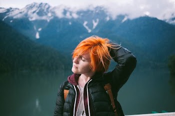 woman in black jacket scratching her head