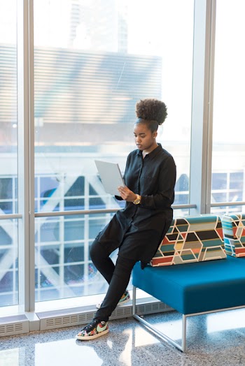 Woman in Black Jacket Standing Near Blue Sofa