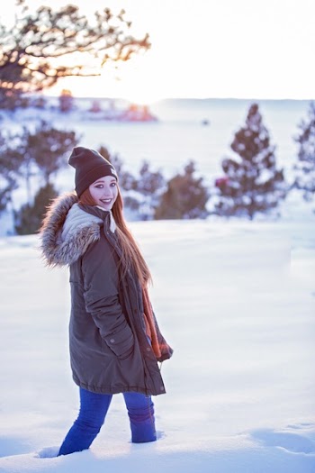 Woman in Black Jacket Walking on Snow Coated Ground