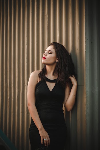 Woman in Black Keyhole Neckline Leaning on Wall