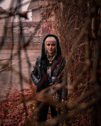 Woman in Black Leather Jacket Near Vines