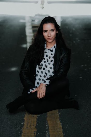 woman in black leather jacket sitting in the middle of the road