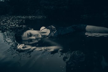 Woman in Black Lingerie Laying on Body of Water