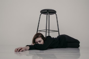 Woman in Black Long Sleeve Shirt Lying on The Floor