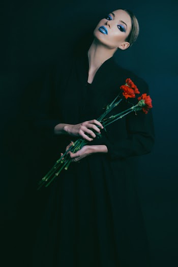 Woman in Black Long-sleeved Dress Holding Red Flowers