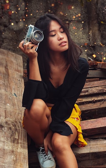 Woman in Black Long-sleeved Shirt and Yellow Skirt Sitting Wooden Stairs Holding Bridge Camera