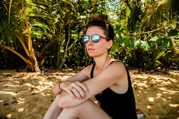 Woman in Black Monokini Sitting on Gray Sand