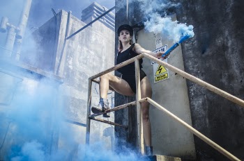Woman in Black Onepiece Holding Smoke Bomb Near Close Door