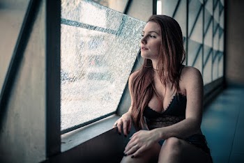 Woman in Black Plunging Neckline Top Looking Through Window