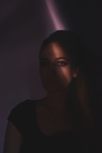 Woman in Black Shirt Inside Dark Room