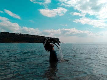 Woman in Black Shirt Lifting Her Hair from Water during Noontime