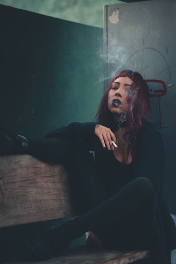 Woman in Black Shirt Sitting and Smoking