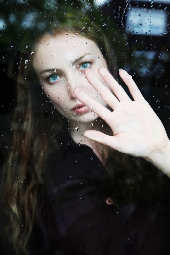 Woman in Black Shirt Standing Behind Glass