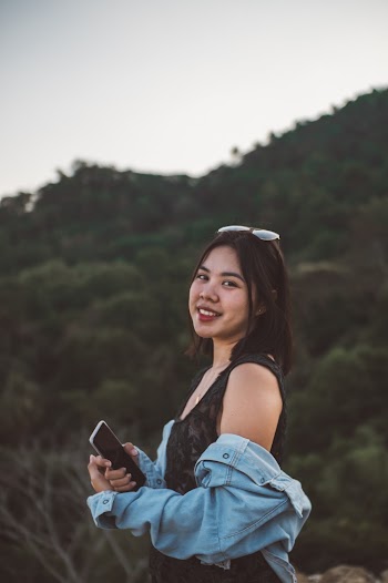 Woman In Black Sleeveless Dress Holding Phone