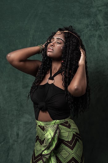 Woman in Black Sleeveless Top and Green Skirt