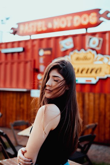 Woman in Black Sleeveless Top Holding Her Arm